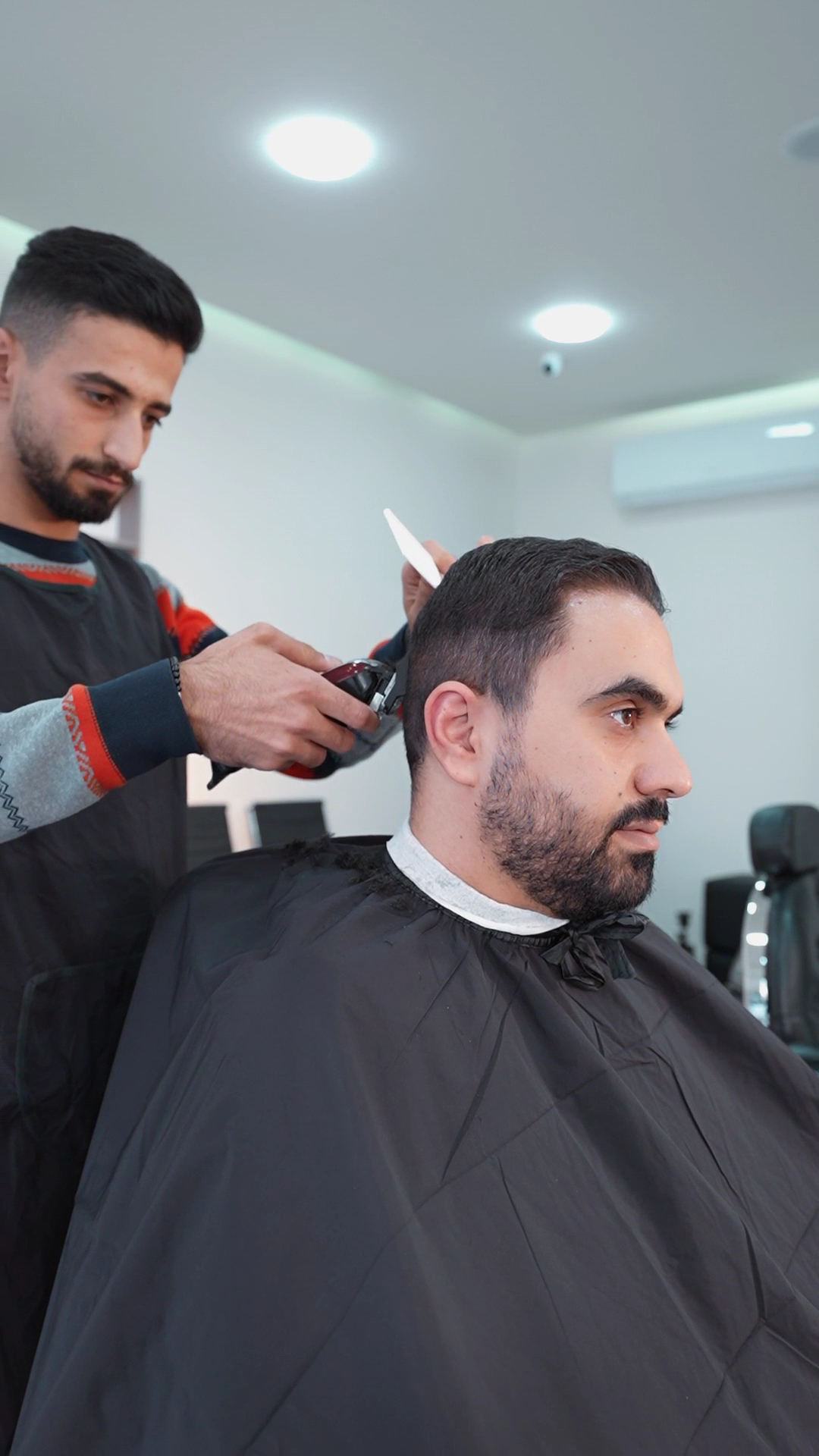Barber working on a client's haircut at The Barber Shop