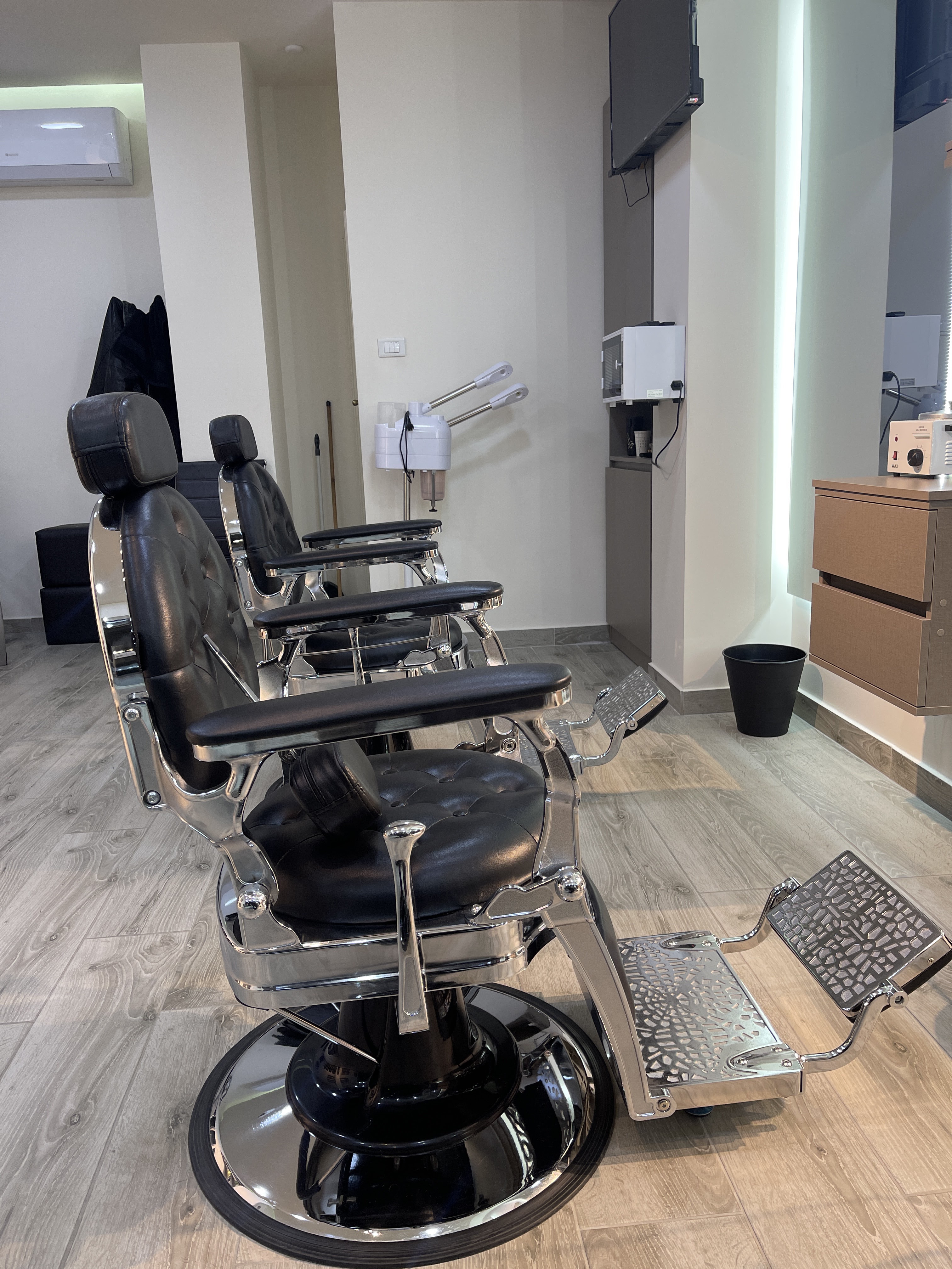 Close-up of a vintage-style chrome barber chair at The Barber Shop